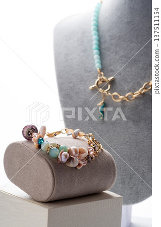 author gold plated bracelete with pearls and gemstones demonstrated against white background. fashion and jewelry concept author gold plated bracelete with pearls and gemstones demonstrated against white background. fashion and jewelry concept 137511154