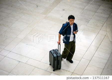 A man carrying luggage at the airport. Photo courtesy of Kansai International Airport (KIX). 137511167