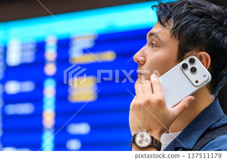 A businessman making a phone call at the airport. Photo courtesy of Kansai International Airport (KIX) A businessman making a phone call at the airport. Photo courtesy of Kansai International Airport (KIX) 137511179