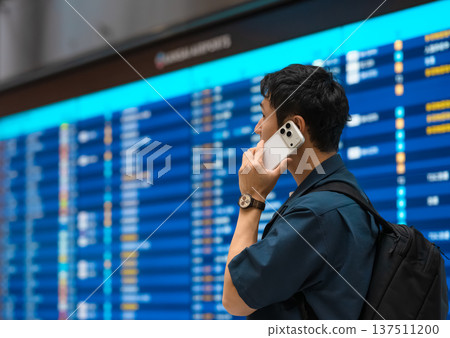 A traveler making a phone call at the airport ■Photography cooperation: Kansai International Airport (KIX) 137511200