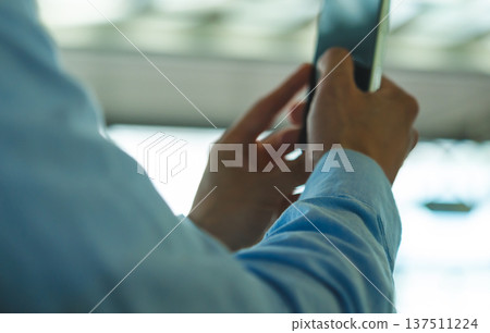 A man operates a smartphone. Photo courtesy of Kansai International Airport (KIX). A man operates a smartphone. Photo courtesy of Kansai International Airport (KIX). 137511224
