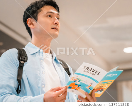 一名男子正在閱讀旅遊指南。照片由關西國際機場(KIX)提供。 一名男子正在閱讀旅遊指南。照片由關西國際機場(KIX)提供。 137511228
