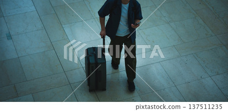 A man pulling a suitcase. Photo courtesy of Kansai International Airport (KIX). A man pulling a suitcase. Photo courtesy of Kansai International Airport (KIX). 137511235