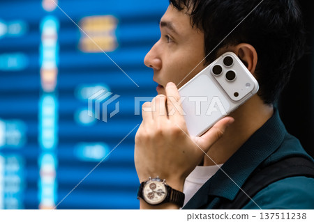 一名男子在機場使用手機通話。照片由關西國際機場(KIX)提供。 一名男子在機場使用手機通話。照片由關西國際機場(KIX)提供。 137511238