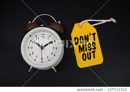 Price tag with message "Do't Miss Out" and alarm clock on black background Price tag with message "Do't Miss Out" and alarm clock on black background 137511312