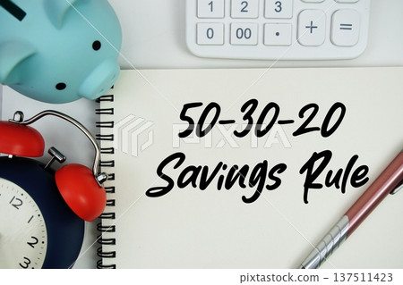 50-30-20 Savings Rule text written notepad with calculator, piggy bank and alarm clock on white background 50-30-20 Savings Rule text written notepad with calculator, piggy bank and alarm clock on white background 137511423