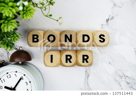 Bonds IRR Bond yield or return platform alphabet letters and alarm clock on marble background Bonds IRR Bond yield or return platform alphabet letters and alarm clock on marble background 137511443