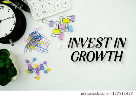 Invest In Growth message with calculator, alarm clock and Stationery on white background 137511457