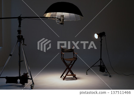 Professional photo studio setup with a director's chair, studio lights, softbox, flash on a boom 137511466