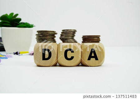 Stack of coins with wood blocks with "DCA (Dollar-Cost Averaging) Stack of coins with wood blocks with "DCA (Dollar-Cost Averaging) 137511483