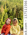 Two happy smiling cute siblings brother and sister boy with girl twins todlers kids pure Children in hoodies outside on nature forest background in sunny summer day. Childhood, family friends concept 137511566