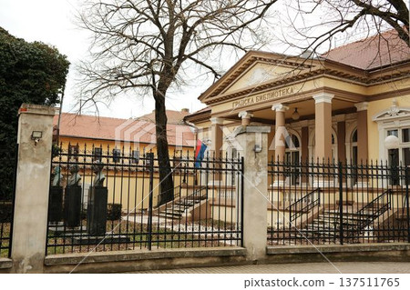 City library building with columns and iron fence in Sombor, Serbia. Cultural institution and historic European architecture concept 137511765