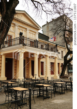 Historic theater building with columns and Serbian flag in Sombor, Serbia. Classical architecture and cultural heritage travel concept in European old town Historic theater building with columns and Serbian flag in Sombor, Serbia. Classical architecture and cultural heritage travel concept in European old town 137511807