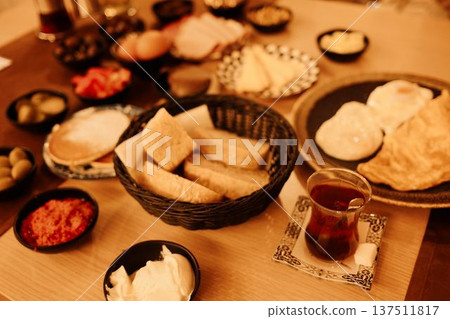Traditional Turkish breakfast served on a table with bread, eggs, cheese, olives, spreads, and tea. Concept of morning ritual, local cuisine, slow food culture, hospitality, and shared dining Traditional Turkish breakfast served on a table with bread, eggs, cheese, olives, spreads, and tea. Concept of morning ritual, local cuisine, slow food culture, hospitality, and shared dining 137511817