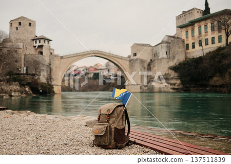 Backpack with Bosnia and Herzegovina flag placed on riverbank near Stari Most bridge in Mostar. Concept of travel, backpacking, freedom and exploration of Balkan heritage Backpack with Bosnia and Herzegovina flag placed on riverbank near Stari Most bridge in Mostar. Concept of travel, backpacking, freedom and exploration of Balkan heritage 137511839