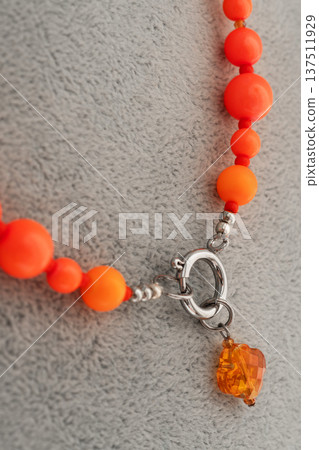 details of beautiful fashionable vibrant necklace with neo orange pearls. fashion and jewelry concept. macro details of beautiful fashionable vibrant necklace with neo orange pearls. fashion and jewelry concept. macro 137511929