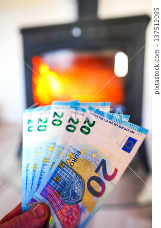 Heating payment. Save money wood stove. Euro money banknotes for payment of heating firewood. Heating payment. Save money wood stove. Euro money banknotes for payment of heating firewood. 137512095