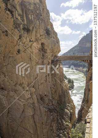 Walking along Caminito del Rey trail in southern Spain near river and cliffs under a partly cloudy sky Walking along Caminito del Rey trail in southern Spain near river and cliffs under a partly cloudy sky 137512197