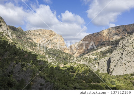 Hiking along Caminito del Rey trail in Spain with views of rocky cliffs and blue sky Hiking along Caminito del Rey trail in Spain with views of rocky cliffs and blue sky 137512199