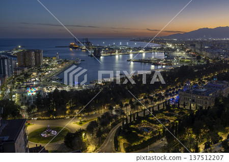 View of Malaga port at dusk with lights from the city and harbor in Spain View of Malaga port at dusk with lights from the city and harbor in Spain 137512207