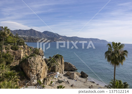 Beach scene in Nerja Spain with clear sky and mountains in the background during daytime Beach scene in Nerja Spain with clear sky and mountains in the background during daytime 137512214