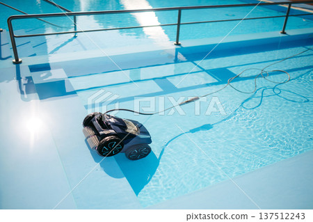 Robotic pool cleaner working underwater to keep swimming pool clean. Robotic pool cleaner working underwater to keep swimming pool clean. 137512243