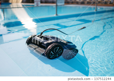 Robotic pool cleaner working underwater to keep swimming pool clean. Robotic pool cleaner working underwater to keep swimming pool clean. 137512244