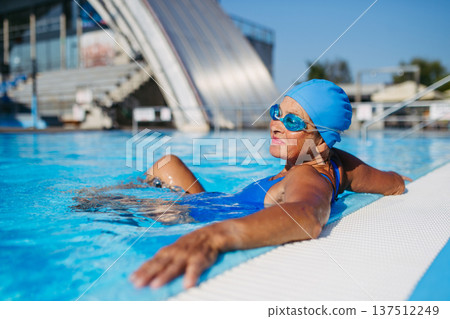 Elderly woman enjoying sport swimming for vitality and longevity. Elderly woman enjoying sport swimming for vitality and longevity. 137512249