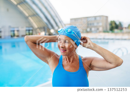 Older female swimmer getting ready for regular fitness swimming. 137512253