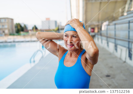 Older female swimmer getting ready for regular fitness swimming. 137512256
