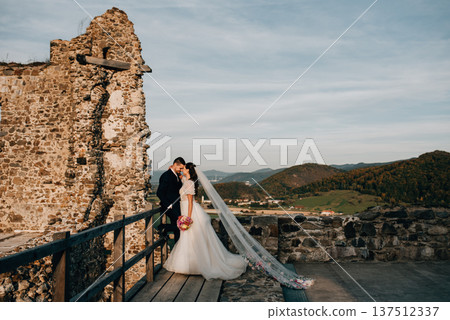 Full length shot of wedding couple hugging, standing outside near ruins. 137512337