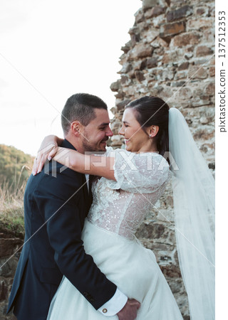 Groom lifting and hugging bride. 137512353