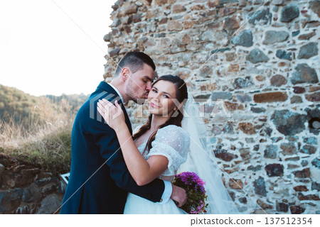 Groom kissing bride on her cheek. Groom kissing bride on her cheek. 137512354