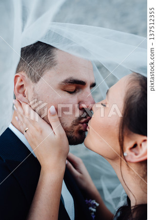 Young wedding couple kissing, standing outside near ruins. 137512355