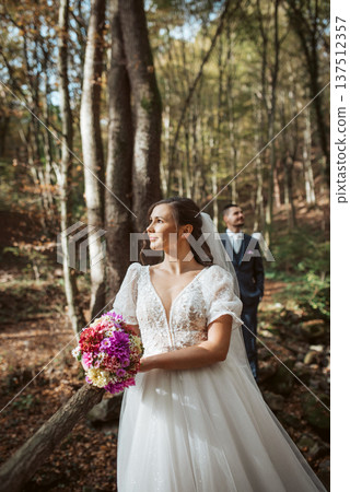 Portrait of bride and an groom in nature, surrounded by a forest. Portrait of bride and an groom in nature, surrounded by a forest. 137512357