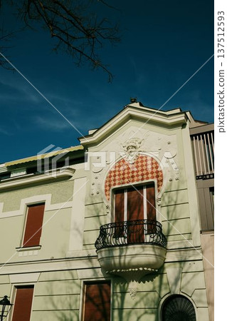Decorative historic residential facade with sculptural ornament and small balcony. Elegant architectural detail on a classic city building in Belgrade 137512593