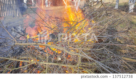 Bonfire made of wood and branches in the garden. Bonfire made of wood and branches in the garden. 137512738