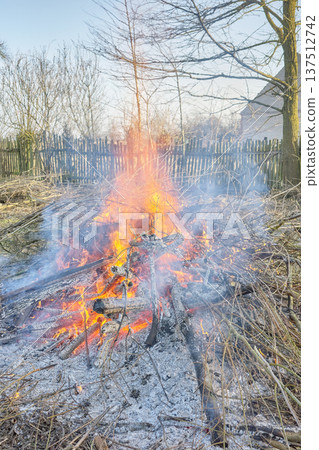 Bonfire made of wood and branches in the garden. Bonfire made of wood and branches in the garden. 137512742