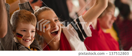 Young German football fans celebrating their team's victory at stadium. 137512803