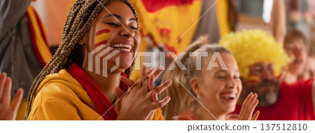 Excited football fans supproting spanish national team in live soccer match at stadium. Excited football fans supproting spanish national team in live soccer match at stadium. 137512810