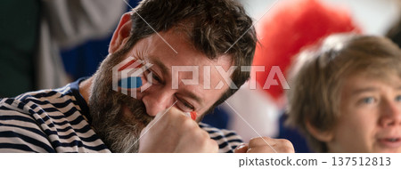 Excited football fans supproting French national team in live soccer match at stadium. Excited football fans supproting French national team in live soccer match at stadium. 137512813