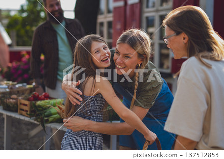 Happy little girl with mother hugging outdoors at community farm. Happy little girl with mother hugging outdoors at community farm. 137512853