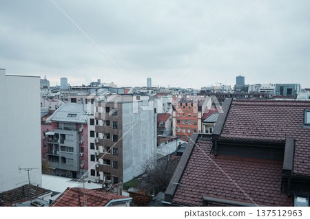 Dense residential architecture with apartment buildings and tiled rooftops in Belgrade city center. Urban landscape showing everyday housing and city development Dense residential architecture with apartment buildings and tiled rooftops in Belgrade city center. Urban landscape showing everyday housing and city development 137512963