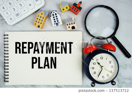 Repayment Plan text written on notepad with house model, magnifying glass and alarm clock on marble background Repayment Plan text written on notepad with house model, magnifying glass and alarm clock on marble background 137513722