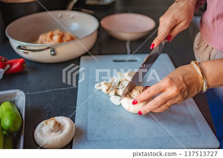 Woman chopping fresh mushrooms for healthy home cooking 137513727