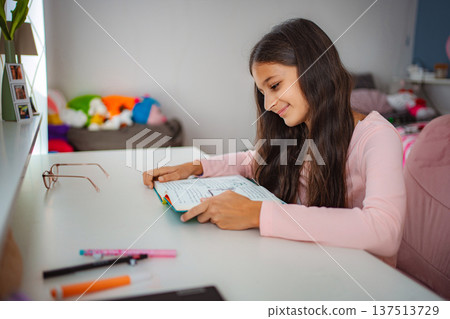 Girl studying homework at desk in her room 137513729