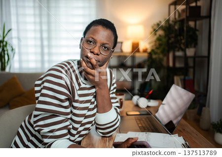 Woman working from home during budget struggles and debt management Woman working from home during budget struggles and debt management 137513789