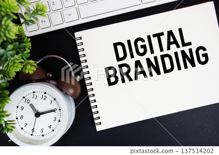 Digital Branding text written on notepad with keyboard and alarm clock on black background Digital Branding text written on notepad with keyboard and alarm clock on black background 137514202