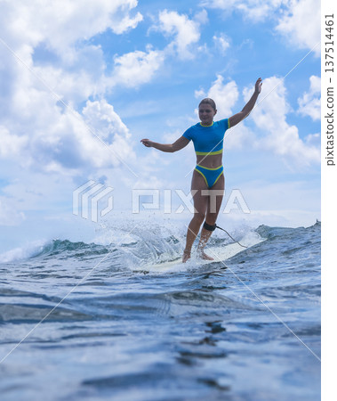 Relaxed Woman Balances On Surfboard Beneath Cloudy Sky During Ocean Swells Relaxed Woman Balances On Surfboard Beneath Cloudy Sky During Ocean Swells 137514461