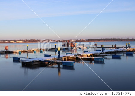 An empty boat dock on a frozen lake in the winter twilight An empty boat dock on a frozen lake in the winter twilight 137514773